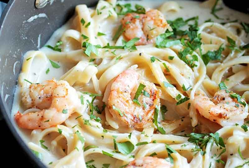 Boil the pasta and put it in the colander. Do not leave the pasta in the boil for a long time to complete everything else with the sauce.  Wash the shrimp well with lemon and vinegar, and it is better to clean the back and hole with a knife and remove any excess.  Season shrimp with garlic and salt.  Heat a frying pan over a medium heat and put the shrimp in it. The most important thing is for the shrimp to retain water and not lose it during cooking, because this makes the shrimp shrink and become dry, and my heart with the pepper is small, it gives a wonderful flavor to the dish.  To make sure that the shrimp is complete, you will find that its color has changed from white to pink.  In another deep frying pan to prepare the sauce, put two tablespoons of vegetable oil and two tablespoons of flour on it and make sure that the flour is completely dissolved in the oil, then add the milk and cream and stir until it becomes thick, then add the shrimp and pasta and stir the ingredients together for a minute.  Add the grated cheese on top of the pasta to melt with the heat of the sauce and give a wonderful flavor.  Serve it hot and do not leave it to cool because if it is left to cool, the sauce will freeze.